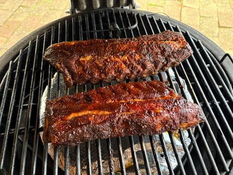 Twee spareribs met een knapperig, gekarameliseerd barbecue glaze op een barbecuerooster