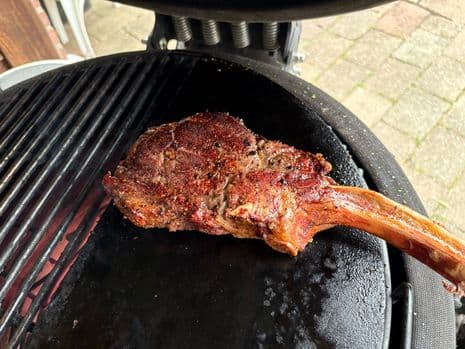 Een gegrilde cowboy steak op een hete speksteen op een barbecue