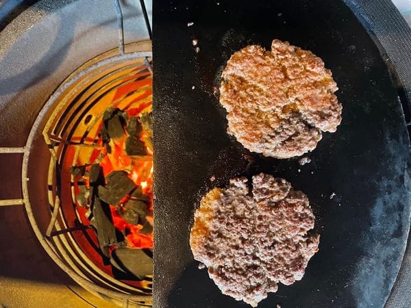 twee burgers op een speksteen in de barbecue