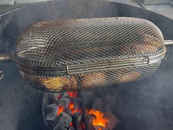 kipvleugels in spitmand boven hete kolen