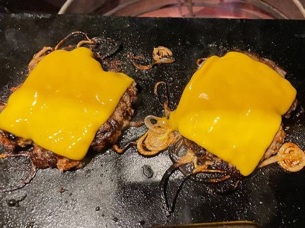 smashburgers op een hete grilplaat met cheddar kaas