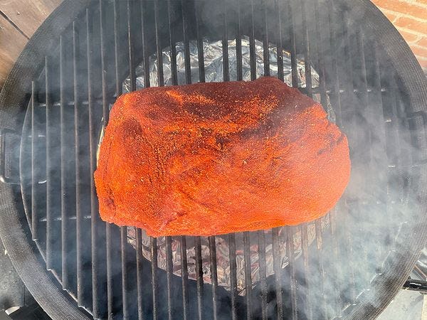 pulled pork op een barbecue rooster met rook er omheen