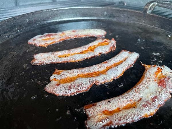 bacon uitbakken op een plancha op de barbecue