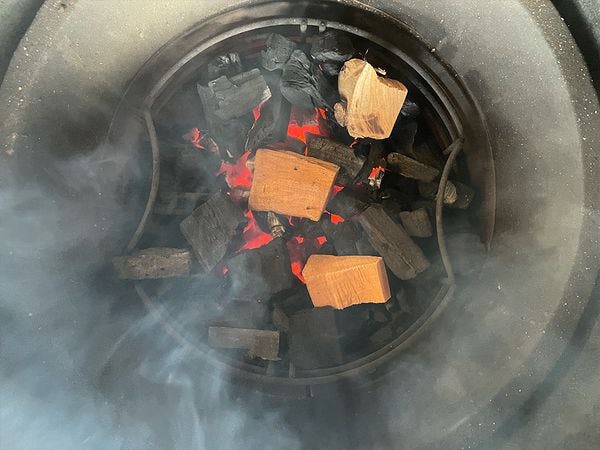 3 chunks rookhout in gloeiende houtskool waar rook vanaf komt
