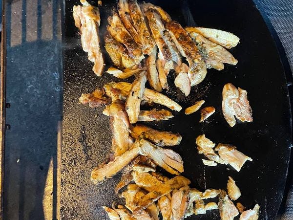 gesneden kip shoarma opbakken op een speksteen in een kamado barbecue