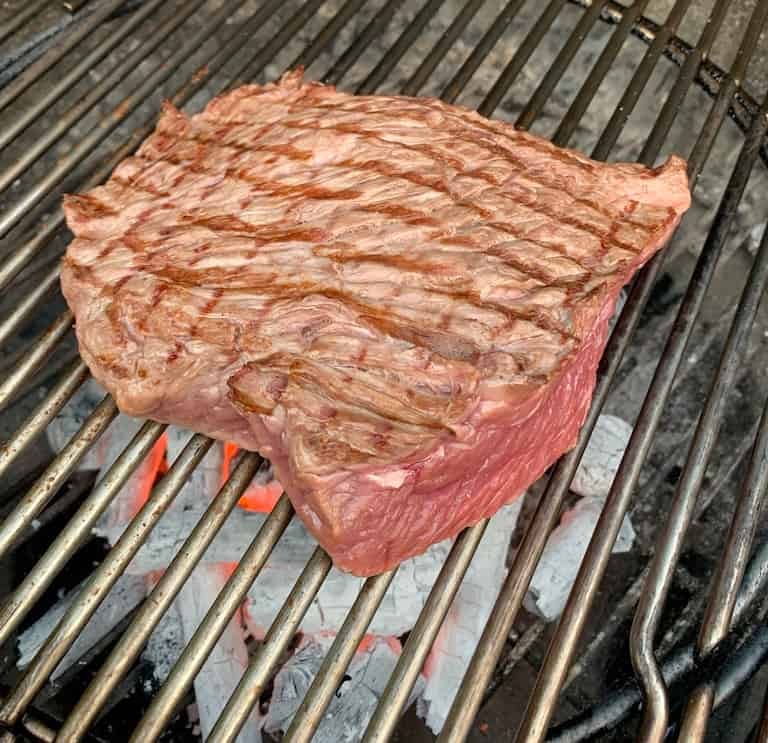 Bavette steak op een barbecue rooster boven hete briketten